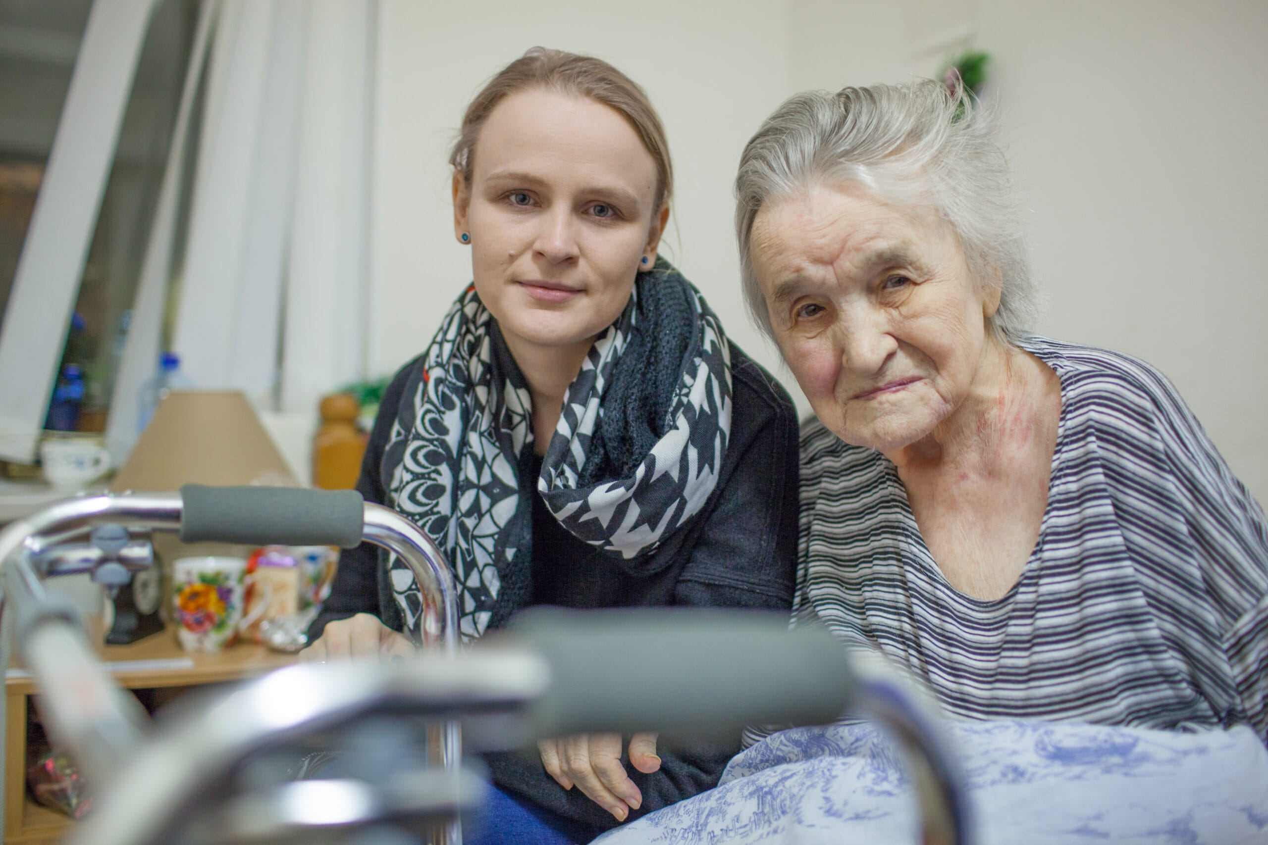A portrait of two women, young and elderly, sitting close to each other